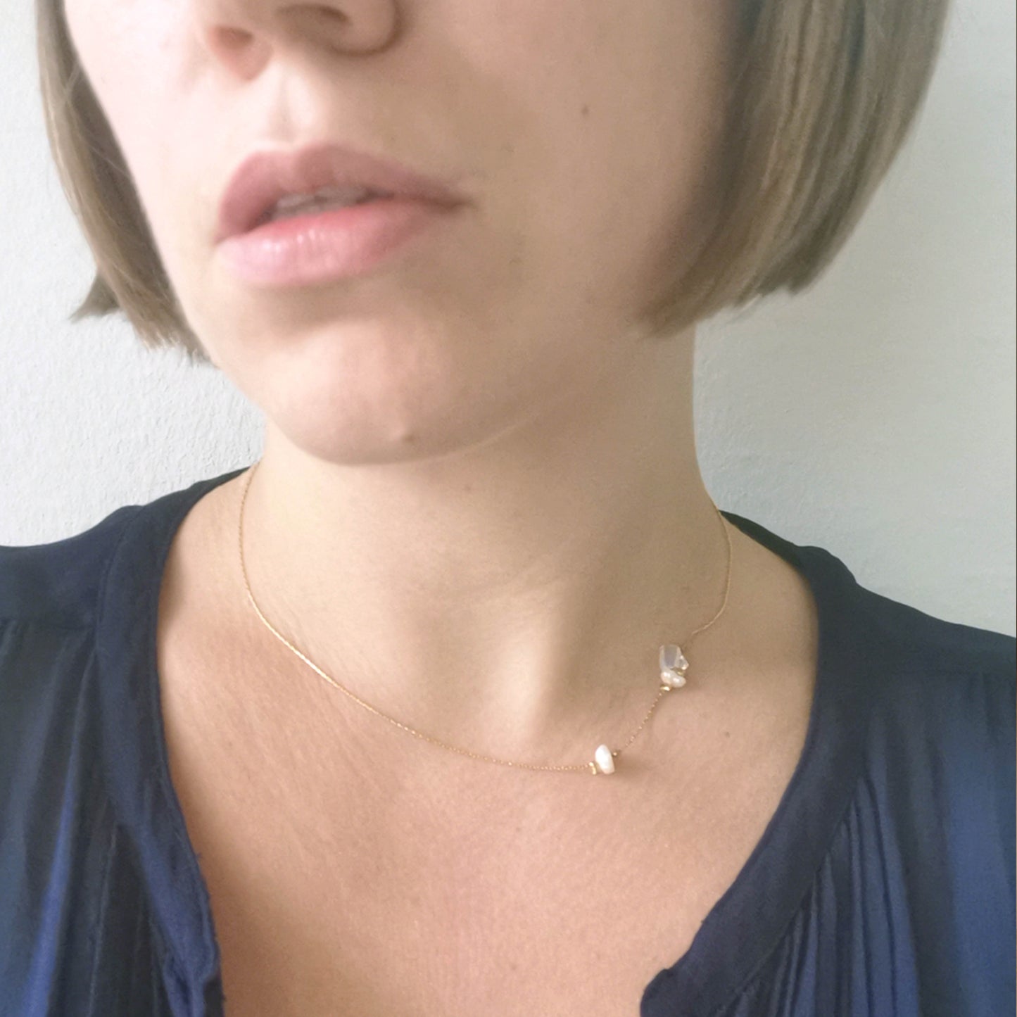Asymmetric opal pearl necklace worn on