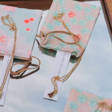 Load image into Gallery viewer, Swarowski and brass charm with fortune cookie packaging packaging
