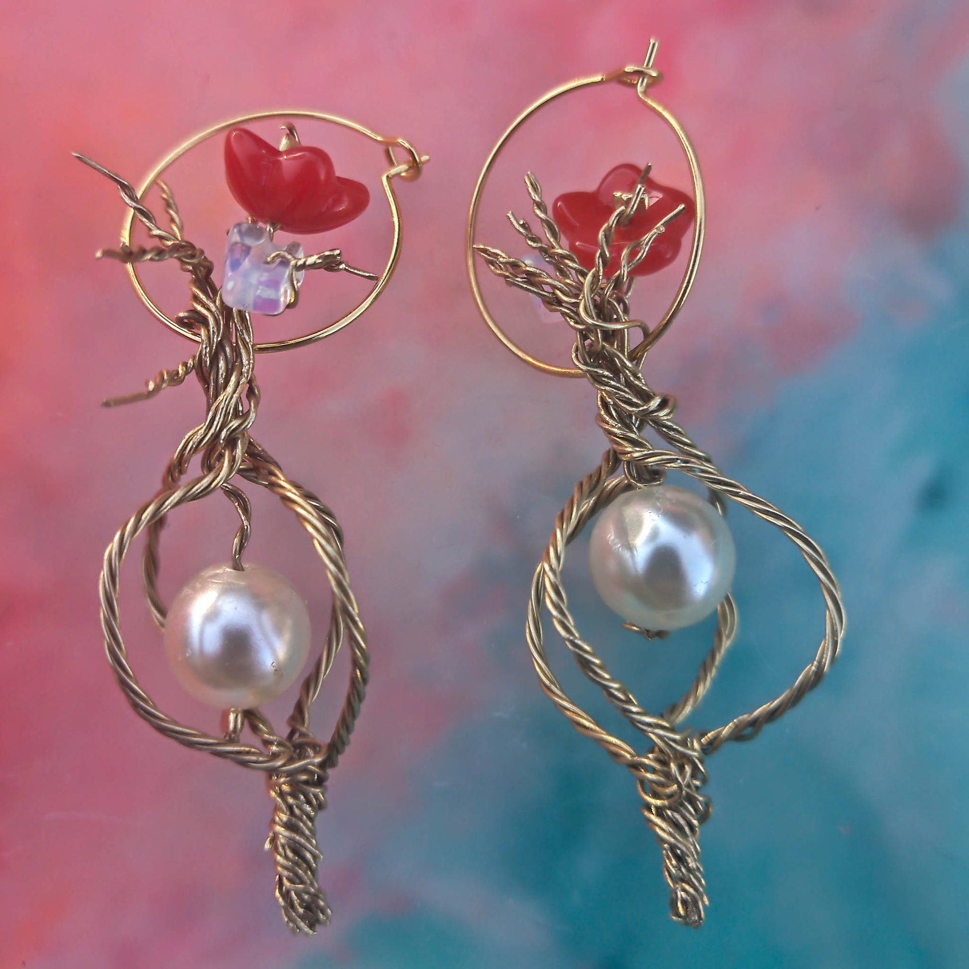 Twisted wire with caged pearl. Top detail has flower and opal details set on standard Camifolla background