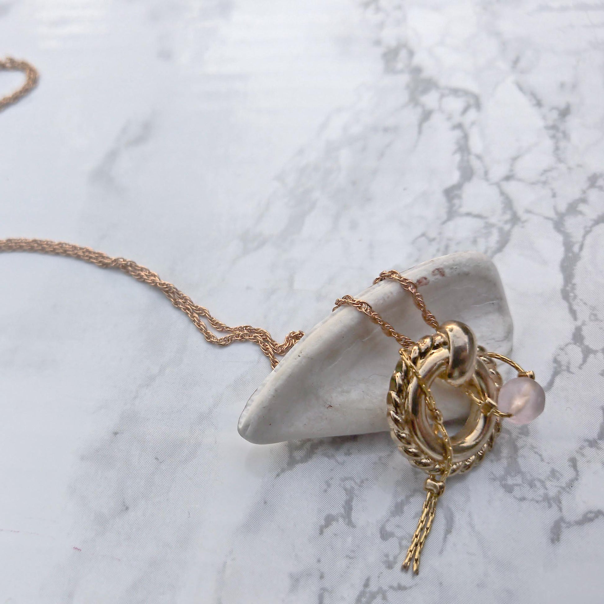 Details of bubblegum necklace's  pendant and chain with pink bead. 