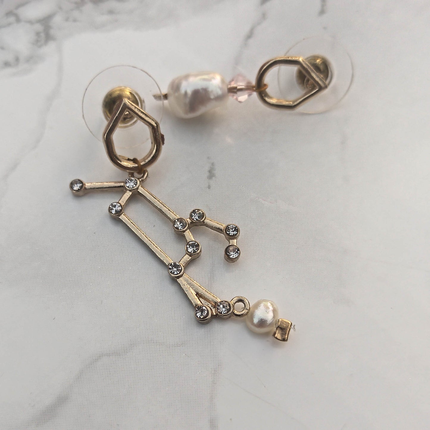 Mismatch Earrings with stellar sign freshwater pearls and swarowski crystals marble background
