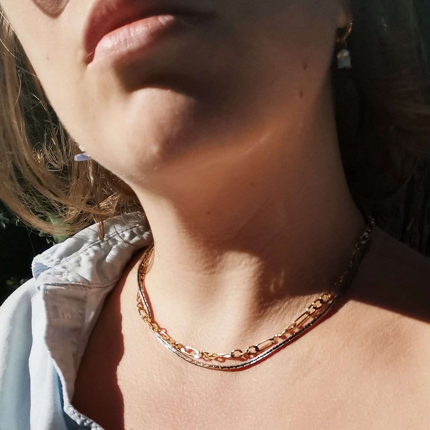 Silver and gold coloured necklace worn on