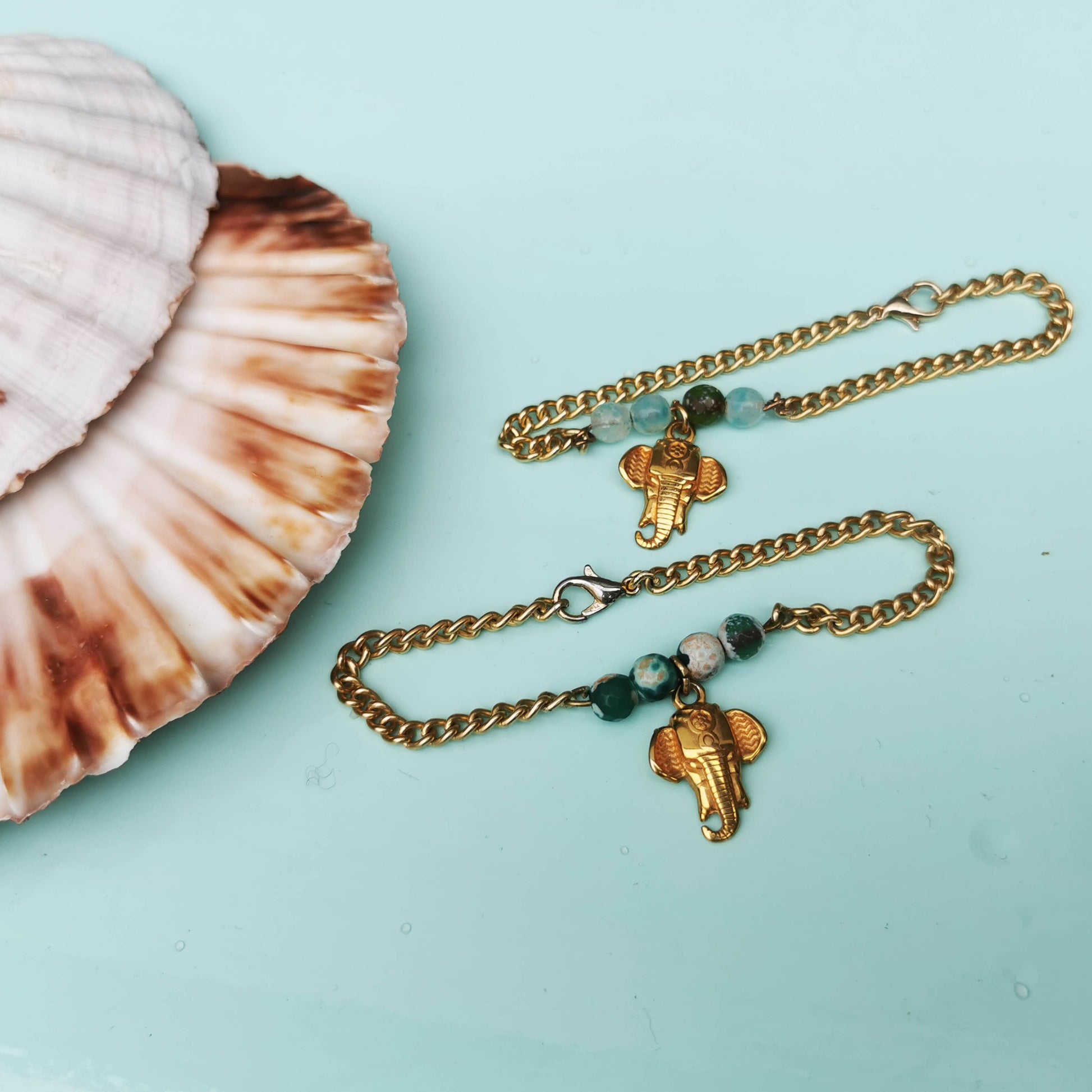 Elephant bracelets on mint background with shell