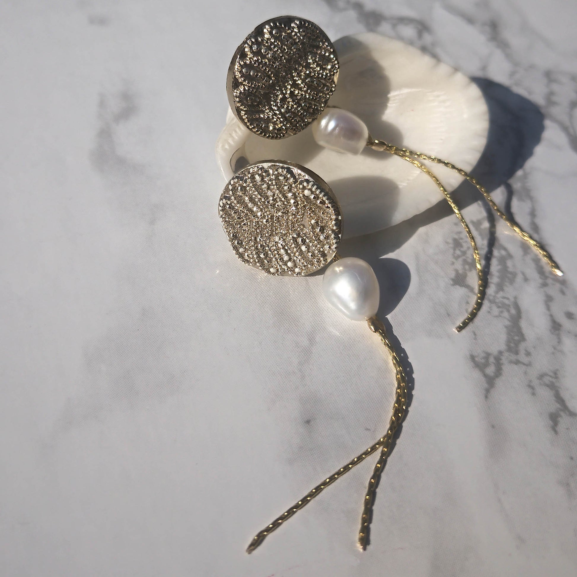 Gold wave stud earrings with freshwater pearl and chain detail 