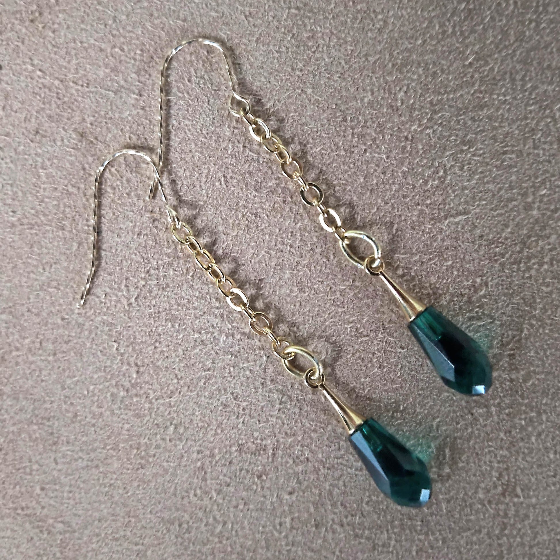 Green swarowski crystals hanging from cable chain earrings. Gold plated twisted hooks 