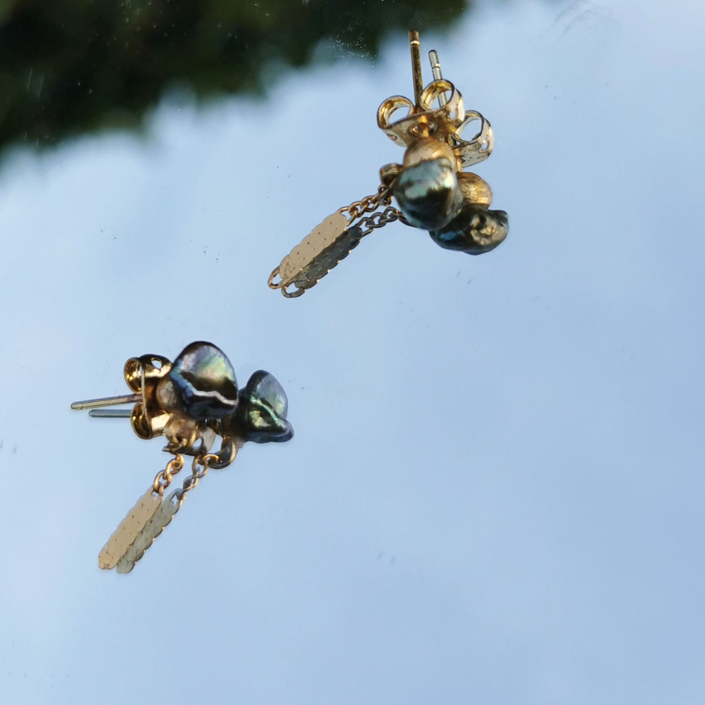 Green  freshwater pearl earrings detail and reflection in mirror