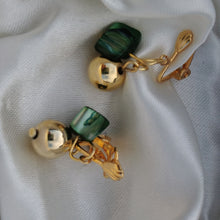 Load image into Gallery viewer, Green shell and bell clip on earrings photographed on silk 
