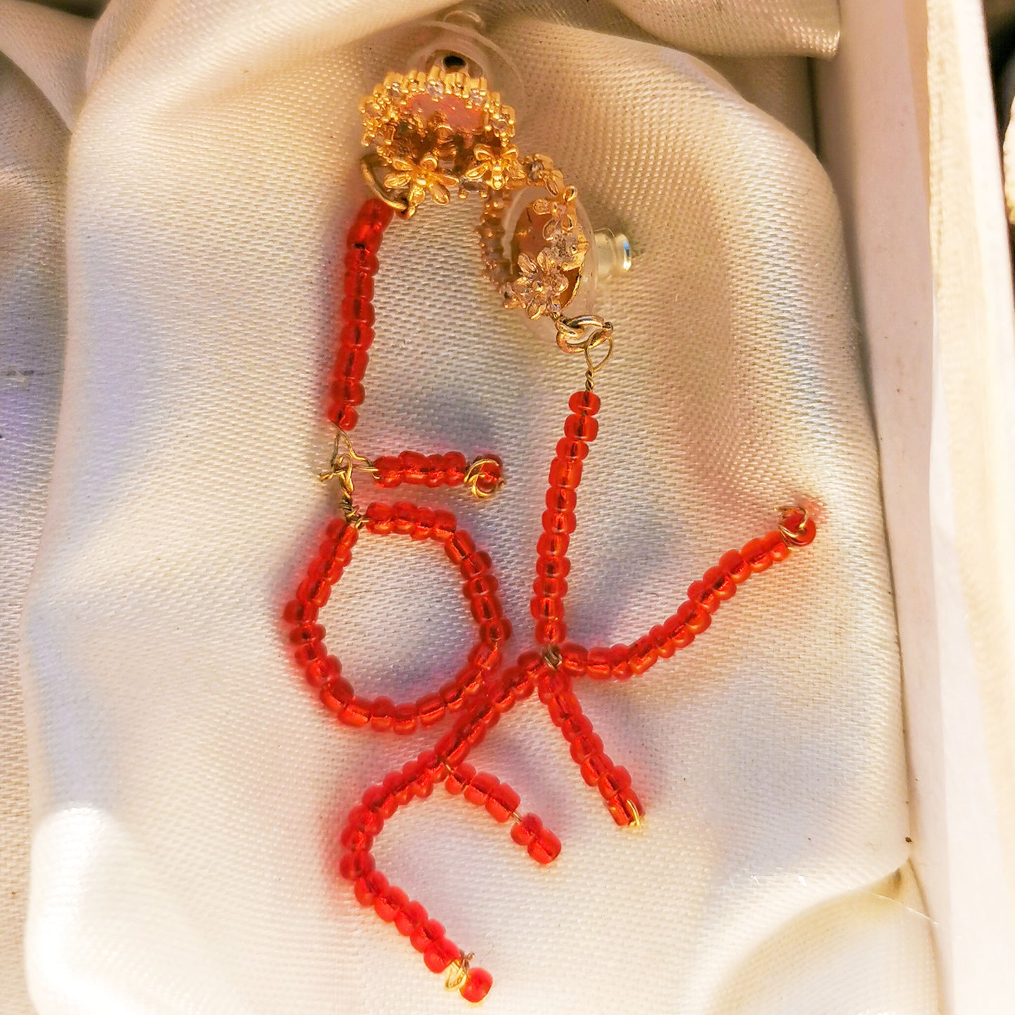 Love earrings photographed on silk