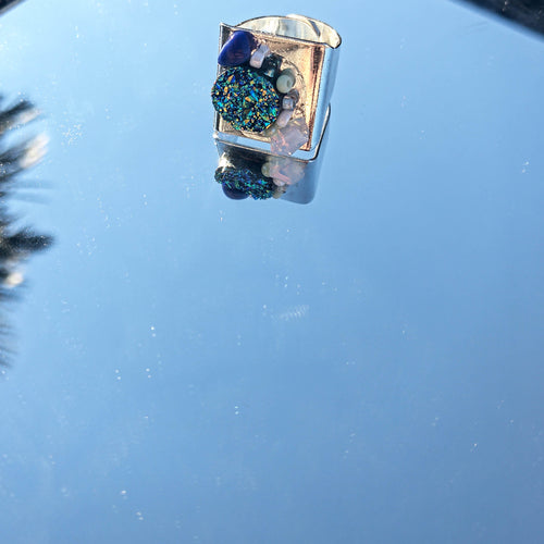 Silver coloured ring with blue, mint and opal details