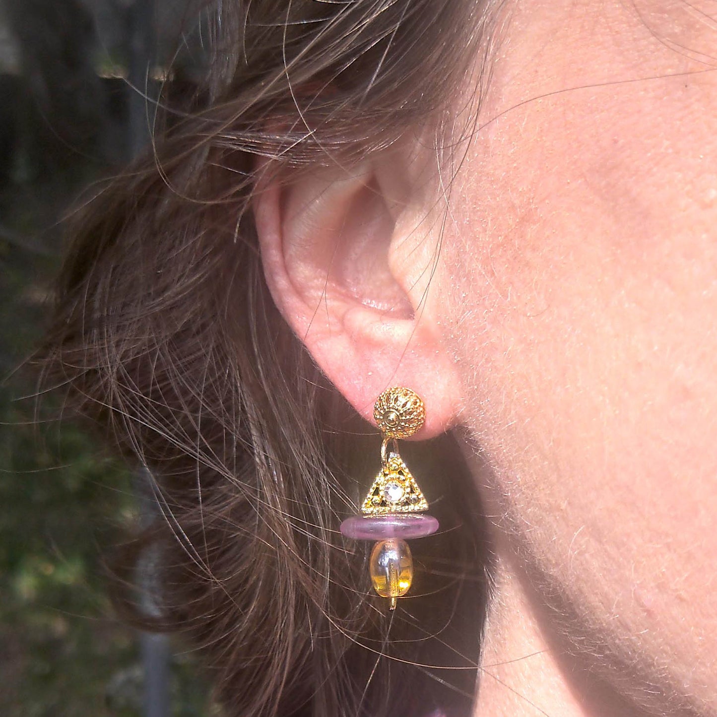 Dainty, yellow and purple Pax earrings worn on 