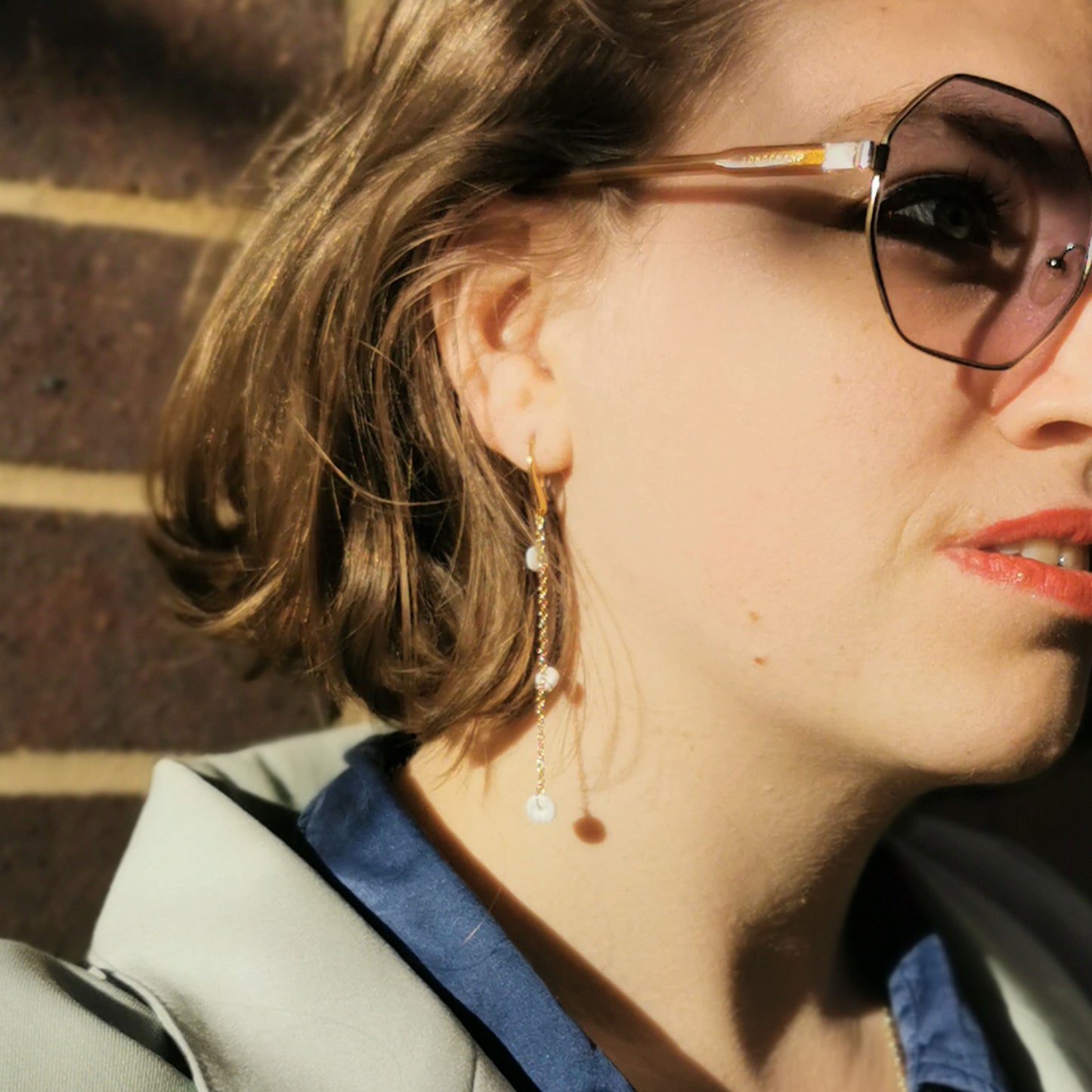 Shell drop earrings worn on