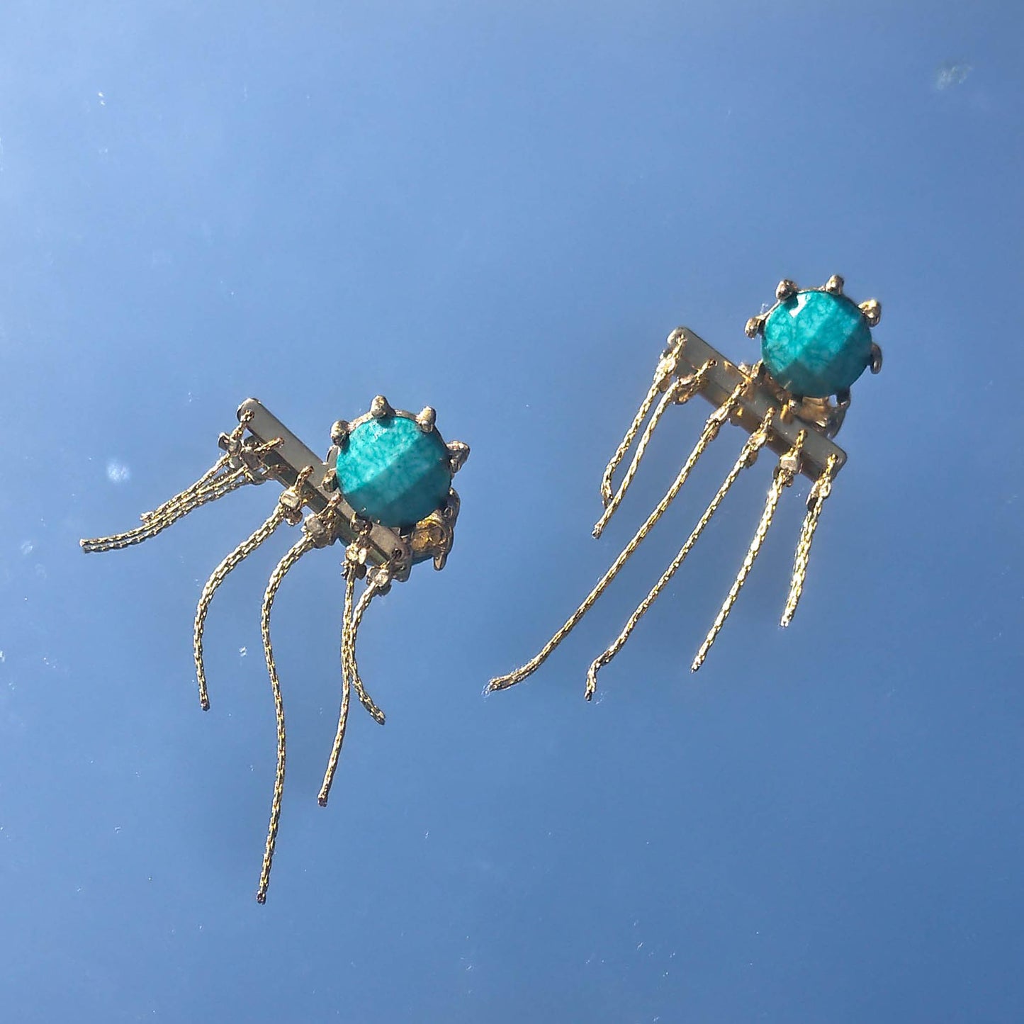 turquoise studded earrings with reflection on them