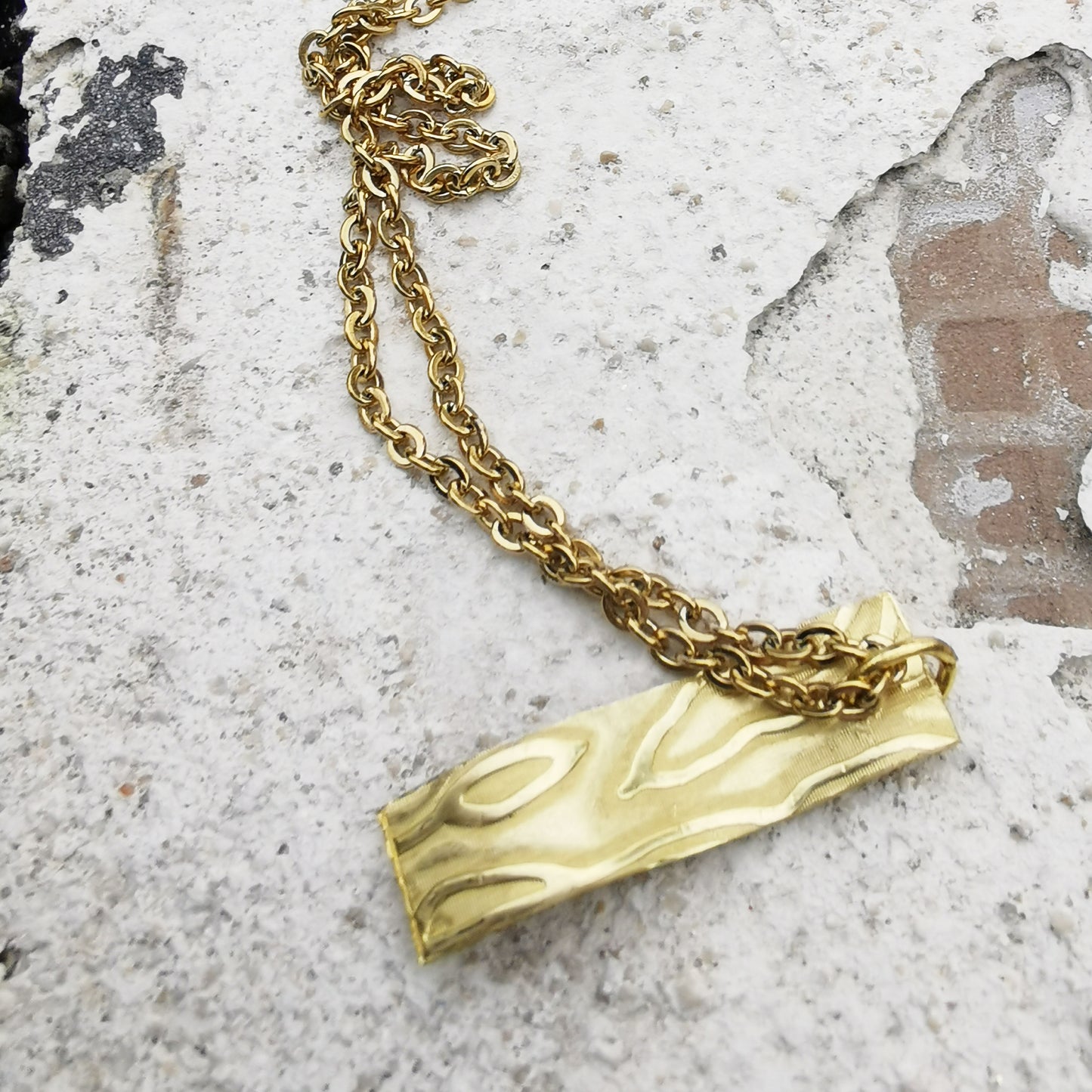 Brass texture Charm Necklace on marble 