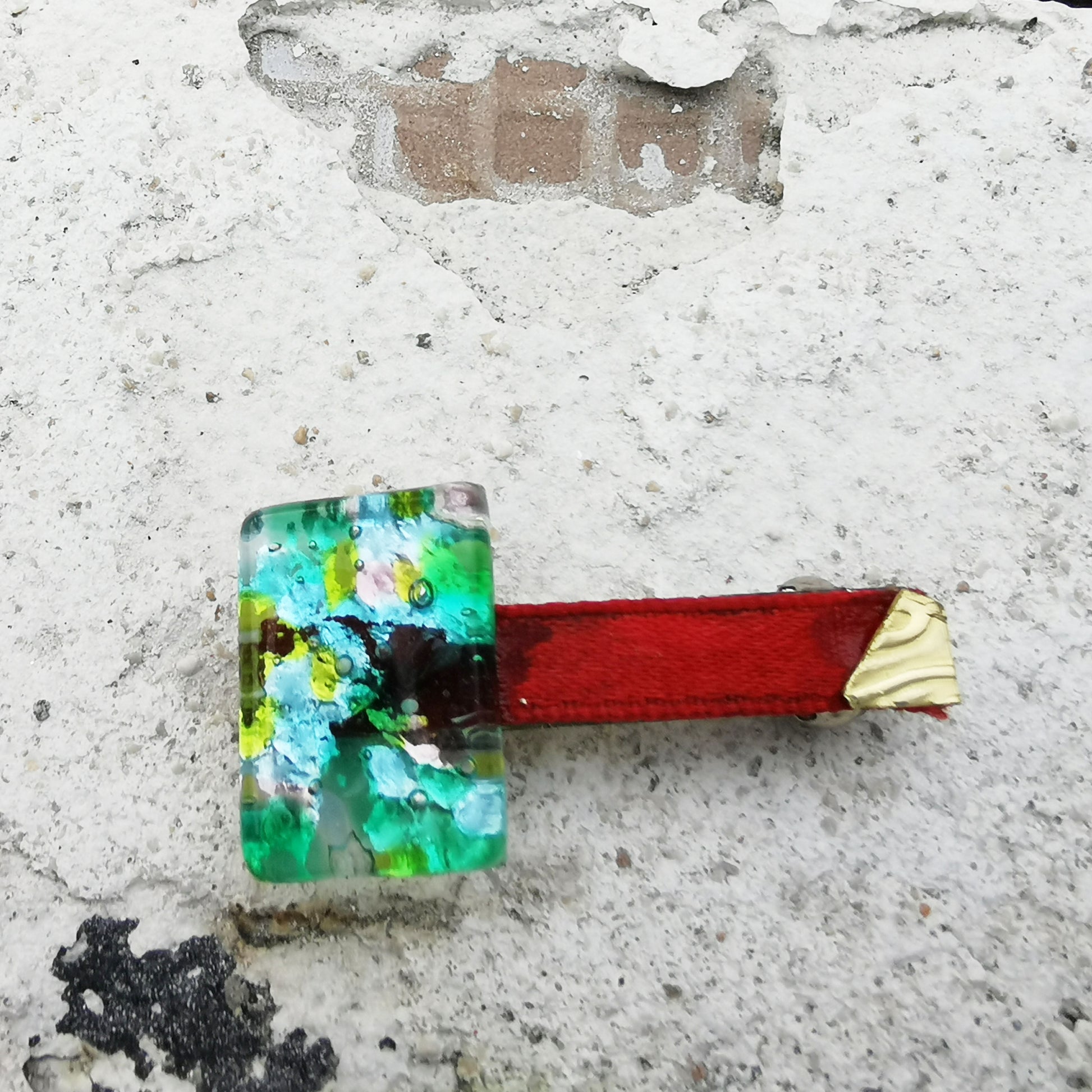 Green glass, red ribbon, brass